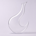 Crescent decanter, a hooked curve of clear crystal balanced on its lower horn